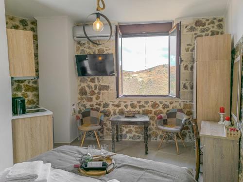 a bedroom with a bed and a table and a window at Achlades The Mountain Paradise Villas - Studio with pool! in Aletrouvárion