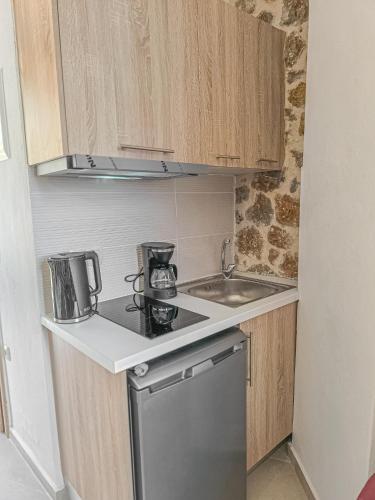 a small kitchen with a stove and a sink at Achlades The Mountain Paradise Villas - Studio with pool! in Aletrouvárion