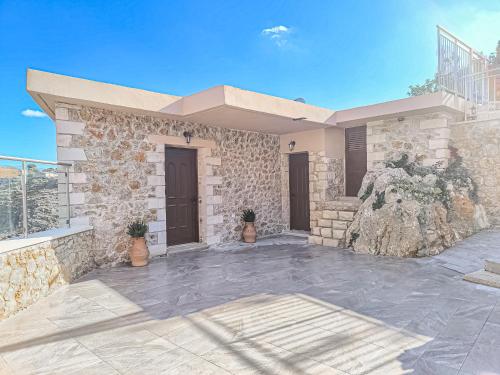 a stone house with a patio and a balcony at Achlades The Mountain Paradise Villas - Studio with pool! in Aletrouvárion