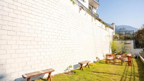 a group of benches sitting next to a brick wall at Chakk 109 Mussoorie Foothills, Dehradun in Dehradun