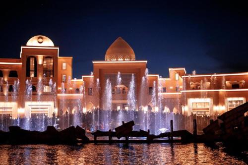 a large building with a fountain in front of it at ЖК Керуен Сарай 5 in Türkistan