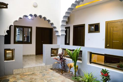 a house with an arched entryway with a plant in a courtyard at Stylish 2BR Modern Apt in Cité Baguida in Lomé