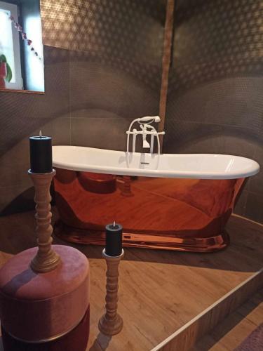 a bath tub with a faucet and two candles at La Ferme de la Cour in Herbeumont