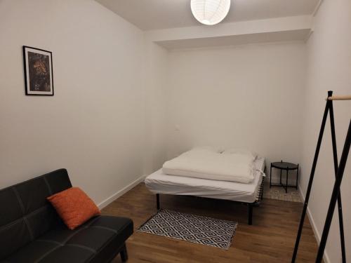 un salon avec un canapé et un lit dans l'établissement Appartement 2 chambres chaumont centre, à Chaumont