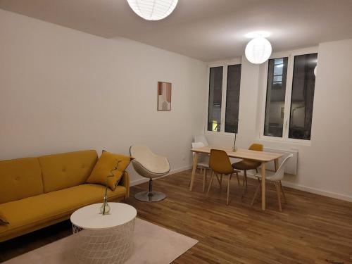un salon avec un canapé et une table dans l'établissement Appartement 2 chambres chaumont centre, à Chaumont
