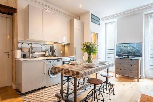 - une cuisine avec une table et quelques tabourets dans l'établissement # République # Paris2 # Chatelêt # 2bedrooms, à Paris