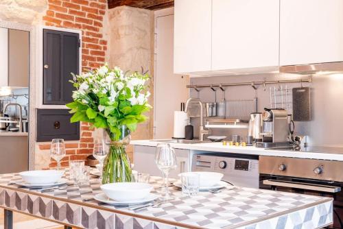 une cuisine avec une table avec un vase de fleurs dans l'établissement # République # Paris2 # Chatelêt # 2bedrooms, à Paris