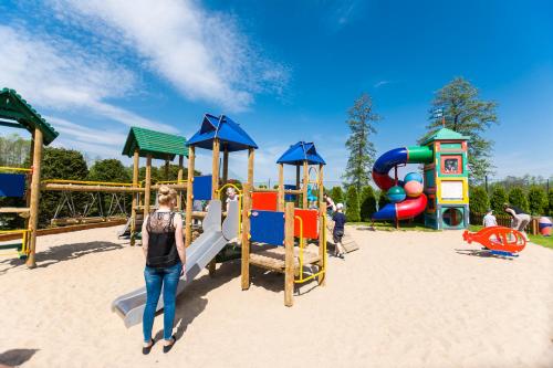 a woman standing in the sand at a playground at Ośrodek Wypoczynkowy Camping Tumiany in Tumiany
