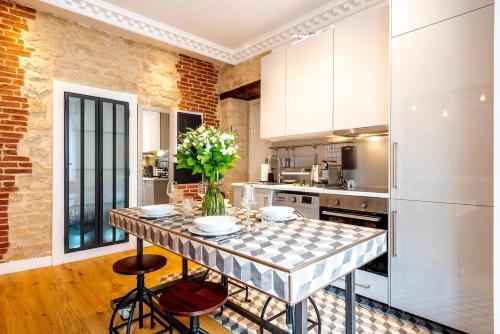 une cuisine avec une table avec un vase de fleurs dessus dans l'établissement # République # Paris2 # Chatelêt # 2bedrooms, à Paris