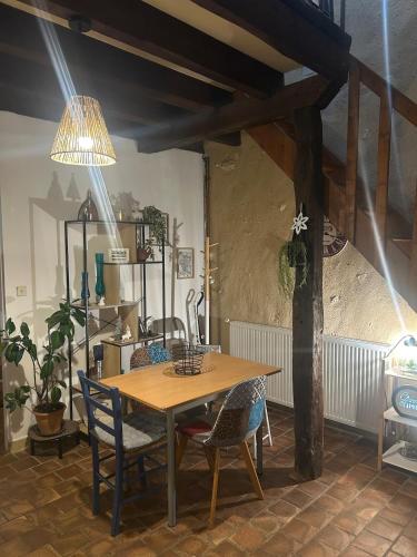 une salle à manger avec une table et des chaises en bois dans l'établissement Studio en campagne Chez Maga, à Foëcy