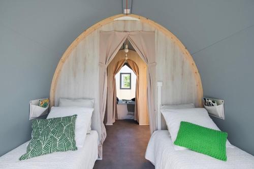 two beds in a room with an arched doorway at AIRE NATURELLE CAMPING LA LOIRE FLEURIE in Le Perrier
