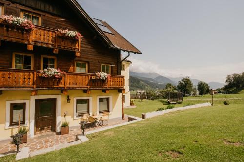 a wooden house with two balconies and a yard at HOFERHOF Schladming -Dachstein in Schladming