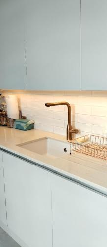 a kitchen counter with a sink and a faucet at Cosy oasis with a view in London