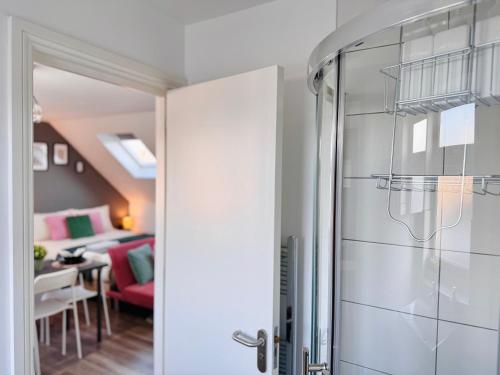 a glass shower door in a room with a living room at Lively Studio Loft 30min to Central London in London