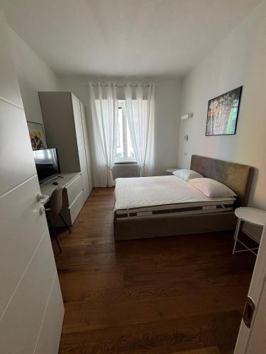 a small bedroom with a bed and a television at settala 10 apartments in Milan