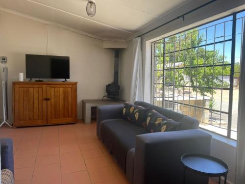 a living room with a couch and a flat screen tv at Raka in Sutherland