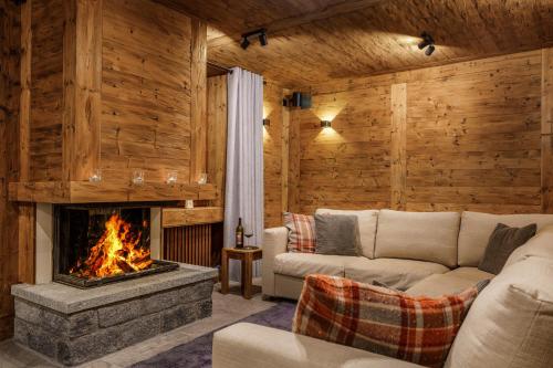 a living room with a couch and a fireplace at Chalet Edelweiss in Saas-Almagell