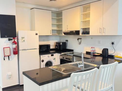 a kitchen with a white refrigerator and a counter top at Dubai damac hills luxurious appartment in Dubai