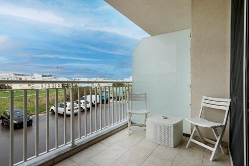 a balcony with chairs and a view of a parking lot at Spacious 2BD Apartment with Large Front Balcony & Country Views - Close to Sea in St Paul's Bay