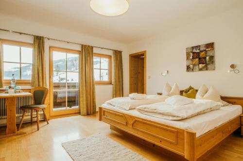 a bedroom with a large bed and a desk at HOFERHOF Schladming -Dachstein in Schladming