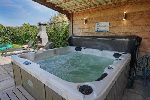 een jacuzzi op een patio met bij Villa Mastlo 2x 10 persons Ouddorp large garden, 1500 meters to the dunes and beach with 2 jacuzzi's - not for companies in Ouddorp