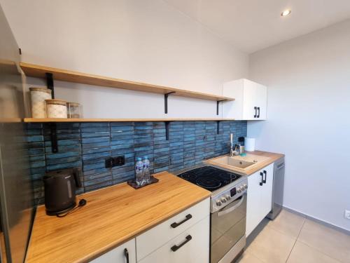 ラドムにあるMieszkanie z dostępem na kodのシンクとコンロのあるキッチン トップオーブン