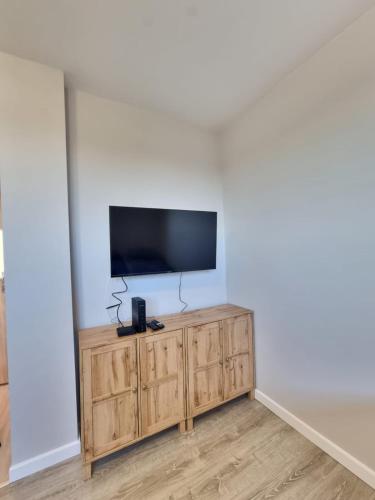 ラドムにあるMieszkanie z dostępem na kodの木製のキャビネットの上に置かれた薄型テレビ