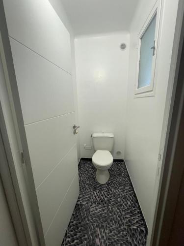 a white bathroom with a toilet and a window at Serre 2 in Belvédère