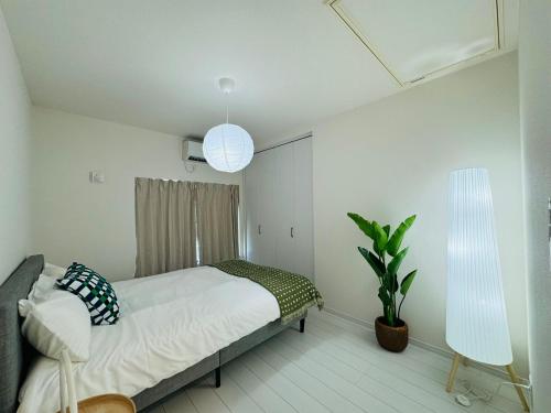 a bedroom with a bed and a plant and two lights at Ikebukuro House-TS0378 in Tokyo