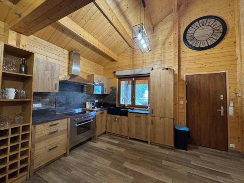 une cuisine avec des armoires en bois et une horloge au mur dans l'établissement Chalet, à Montévrain
