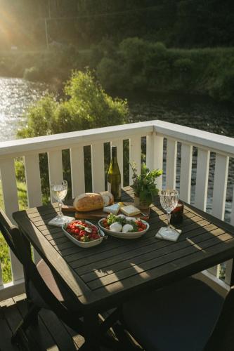 a picnic table with food and wine on a balcony at Forth River Cottage in Forth