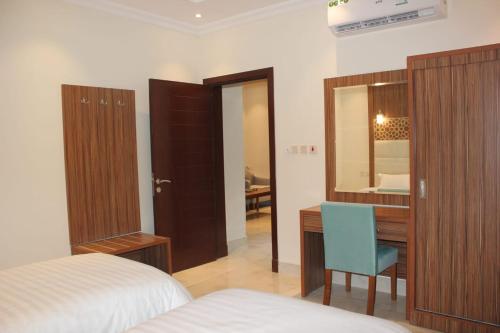 a bedroom with a bed and a desk and a mirror at AL Tamayoz Al Raqi - Alfaisaliyah branch in Jeddah