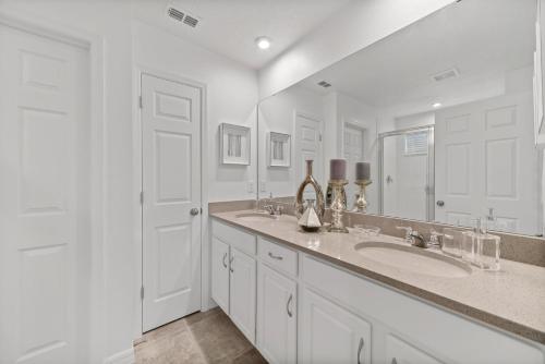 a white bathroom with a sink and a mirror at The Ultimate Mansion on Solara Resort Orlando Mansion 5304 in Kissimmee