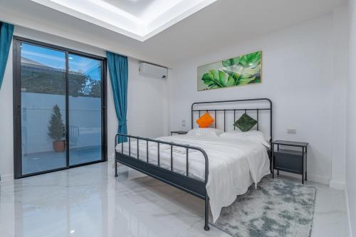 una camera da letto con un letto e una grande finestra di 芭提雅市中心 现代轻奢 独栋双层泳池别墅 五房六卫 全新 大空间 a Jomtien Beach