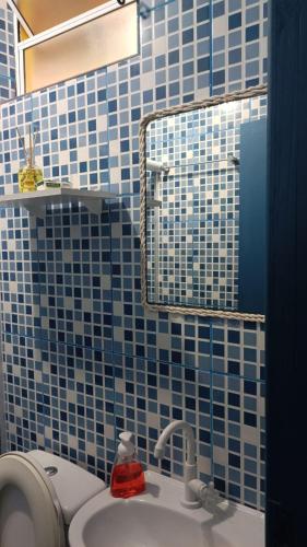 a blue tiled bathroom with a sink and a mirror at Pousada Vida Simples in São Francisco do Sul