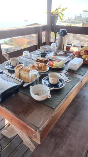 a table with bread and other food on it at Pousada Vida Simples in São Francisco do Sul