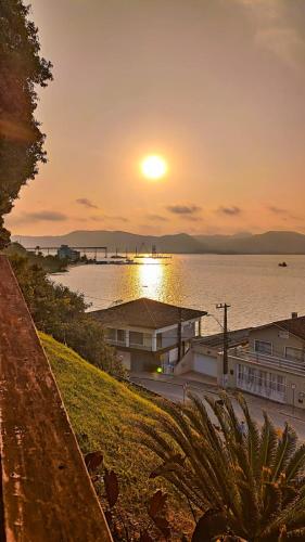 a sunset over a body of water with a pier at Pousada Vida Simples in São Francisco do Sul