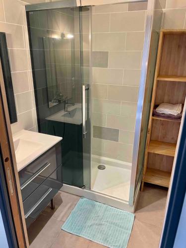 une douche avec une porte vitrée dans une salle de bain dans l'établissement Step-free fisherman's house in Penmarch, à Penmarcʼh