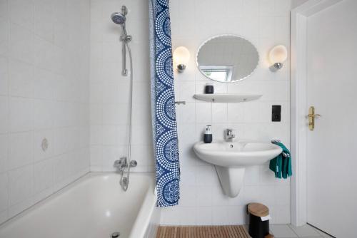 a bathroom with a tub and a sink and a mirror at Ferienwohnungen Christina Erisgen in Olderup