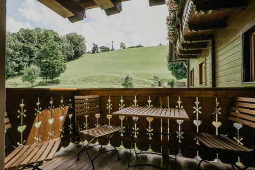 a porch with two chairs and a table and a field at HOFERHOF Schladming -Dachstein in Schladming