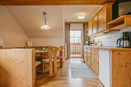 a kitchen with wooden cabinets and a dining room at HOFERHOF Schladming -Dachstein in Schladming
