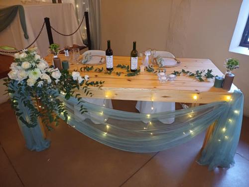 a table with bottles of wine and flowers on it at Ongegund Lodge in Somerset West