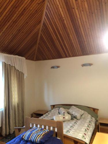 a bedroom with a bed with a wooden ceiling at Grand Elion in Rēzekne