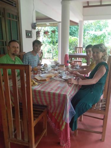 a group of people sitting around a table at Sigiriya Moonlight Home in Sigiriya