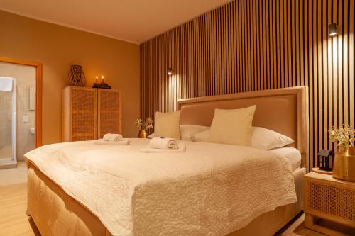 a bedroom with a large bed with towels on it at STING Boutique Apartments in Ostrava