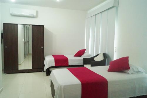a hotel room with two beds and a mirror at Hotel Florida Sincelejo in Sincelejo