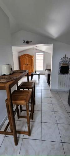 une salle à manger avec une table et des bancs sur du carrelage dans l'établissement Studio aux deux terrasses, à Puiseux-en-France