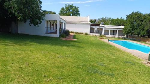 a house with a swimming pool in a yard at Ongegund Lodge in Somerset West