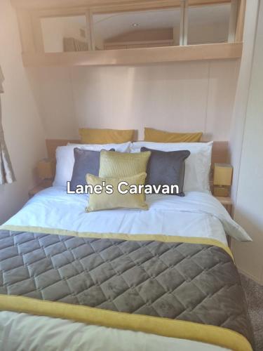 a bedroom with a bed with the words lanes caravan at Southview holiday park caravan in Skegness