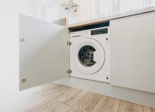 a white laundry room with a washer and dryer at The Bay Hideaway - Lovely 2bd house - up to 6 people in Cardiff